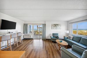 een woonkamer met een bank en een tafel bij Sugar Sands Beachfront Hotel, a By The Sea Resort in Panama City Beach