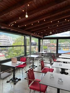 a large room with tables and chairs and windows at Stone Bridge Hotel in Peje +25 photos