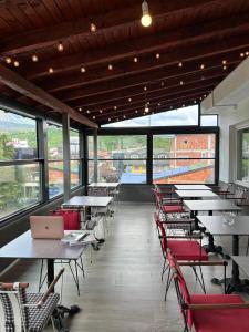 a restaurant with tables and chairs with a laptop on them at Stone Bridge Hotel in Peje