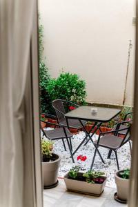 un patio con mesa, sillas y macetas en Hermes Modern Apartment en Alexandroupolis