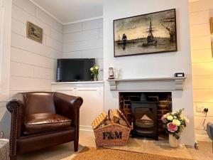 ein Wohnzimmer mit einem Stuhl und einem Kamin in der Unterkunft Stylish 3BR Cowes Cottage Close To The Waterfront in Cowes