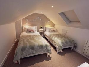 1 Schlafzimmer mit 2 Betten im Dachgeschoss in der Unterkunft Stylish 3BR Cowes Cottage Close To The Waterfront in Cowes