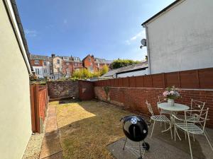 eine Terrasse mit Tisch und Stühlen und einem Zaun in der Unterkunft Stylish 3BR Cowes Cottage Close To The Waterfront in Cowes