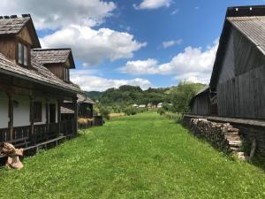 an alley between two old buildings in a field at Casa dintre dealuri in Rozavlea