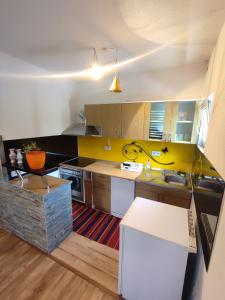 a kitchen with yellow and white cabinets and a table at Sarajevo Paradise in Sarajevo