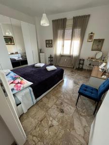a bedroom with a bed and a blue chair at App di Myrò in Reggio Emilia