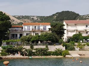 a building on the shore of a body of water at Apartments Vila Miranda on the beach in Barbat na Rabu