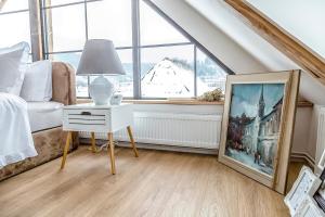 a bedroom with a bed and a table with a lamp at Casa dintre dealuri in Rozavlea