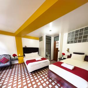 a hotel room with two beds and a chair at MACHUPICCHU BOUTIQUE in Machu Picchu
