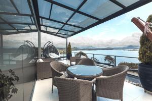 einen Balkon mit einem Tisch und Stühlen sowie Blick auf das Wasser in der Unterkunft Luxé Cabañas in Guatapé