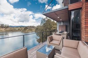 a balcony with chairs and a view of the water at Luxé Cabañas in Guatapé