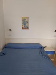 een slaapkamer met een bed met een blauwe sprei bij Appartamenti Marazzurro in Peschici