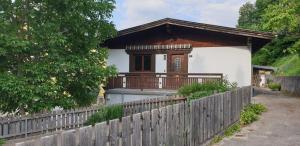 ein Haus mit einem Holzzaun davor in der Unterkunft Ferienwohnung Singer in Völs