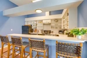 a kitchen with a bar with chairs and a counter top at Renovated San Marcos Vacation Rental with Balcony! in San Marcos