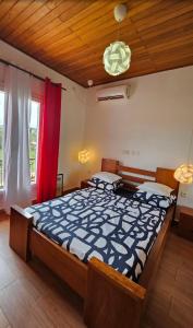- une chambre avec un grand lit et une fenêtre rouge dans l'établissement Nandy's home, à Odza II