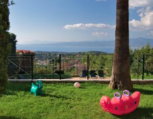 deux animaux jouets assis dans l’herbe à côté d’un arbre dans l'établissement Amazing Villa with private pool, à Markópoulon Oropoú