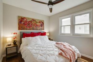 a bedroom with a white bed with red pillows at Pet-Friendly Minneapolis Home about 8 Mi to Downtown! in Minneapolis