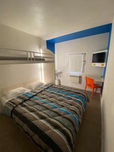 a bedroom with a bed and a desk with a chair at N&Z HOTELS in Trappes +35 photos