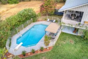 una vista aérea de una piscina frente a una casa en Spacious home with pool, bar, game room, parking, on 5 private acres., en Oroville