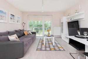 uma sala de estar com um sofá e uma televisão em Comfy Apartment Kapitańska & Parking & Balcony by Renters em Gdynia