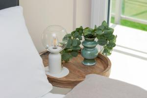 a table with vases and a candle and a plant at Comfy Apartment Kapitańska & Parking & Balcony by Renters in Gdynia