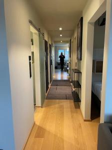 a hallway with a person walking down a hallway at Frognervein Terrace Penthouse in Oslo
