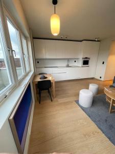 a living room with a table and a kitchen at Frognervein Terrace Penthouse in Oslo