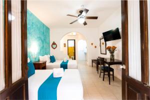 a hotel room with a bed and a desk at Hotel Casa de las Flores in Playa del Carmen