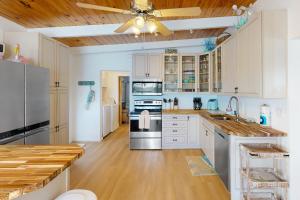 a kitchen with white cabinets and a ceiling fan at Saylor's Bay in Key Colony Beach