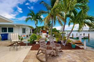 ein Haus mit Stühlen, einem Tisch und Palmen in der Unterkunft Saylor's Bay in Key Colony Beach