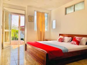 1 dormitorio con cama y ventana grande en Blossom Rest, en Kandy