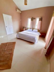a large bedroom with a large bed and two windows at Just Chill Villa in Trou aux Biches