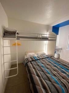 a bedroom with a bunk bed with a ladder at N&Z HOTELS in Trappes