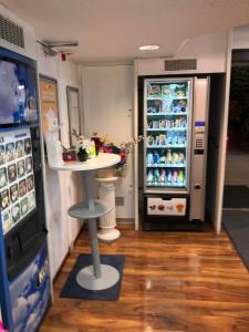 a restaurant with a refrigerator and a table in front of it at N&Z HOTELS in Trappes