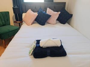a bed with black and white towels on it at Green Apartments in Invergowrie