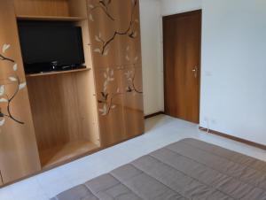 Zimmer mit einem Flachbild-TV und einer Tür in der Unterkunft Le Stanze di Polly in Foligno