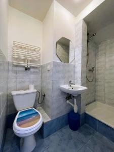a bathroom with a toilet and a sink and a shower at Apartament Bea Mar in Gdynia
