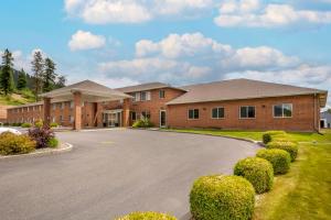 a house with a driveway in front of a building at Comfort Inn in Colville