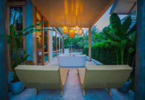 porche con 2 sillas y bañera en Chiangmai Boutique Pool Villa, en Chiang Mai