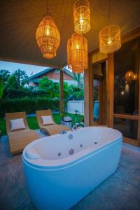 - Sala de estar con bañera y lámparas de araña en Chiangmai Boutique Pool Villa, en Chiang Mai