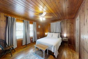 um quarto com uma cama e uma ventoinha de tecto em The Little Brick Cottage em Myrtle Beach