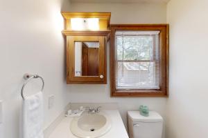 ein Badezimmer mit Waschbecken, Toilette und Spiegel in der Unterkunft The Little Brick Cottage in Myrtle Beach + 13 Fotos