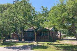 ein kleines Haus inmitten von Bäumen in der Unterkunft The Little Brick Cottage in Myrtle Beach
