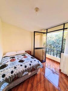 Ricardo PalmaにあるCasa Campestre El Huertoのベッドルーム1室(ベッド1台、大きな窓付)