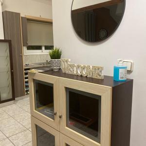 baño con espejo y armario de madera en Comfort and relaxation, en Pireo