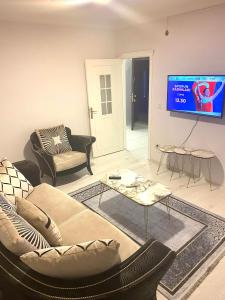 a living room with a couch and a tv at Kuzey suite home in Trabzon