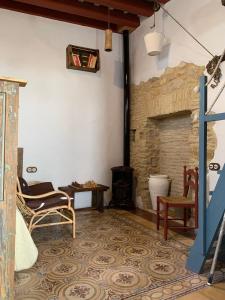 een woonkamer met stoelen en een stenen open haard bij Casa Nayib in Vejer de la Frontera