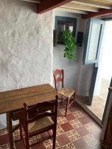 een eetkamer met een houten tafel en stoelen bij Casa Nayib in Vejer de la Frontera