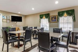 Quality Inn Conyers I-20 في كونيرز: مطعم بطاولات وكراسي وتلفزيون بشاشة مسطحة