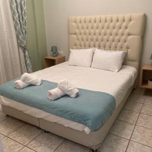 een slaapkamer met een groot bed en handdoeken bij Comfort and relaxation in Piraeus